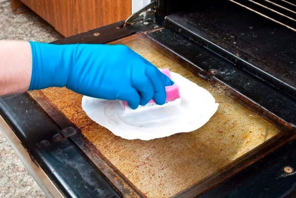 Professional cleaners with detailed oven cleaning after moving